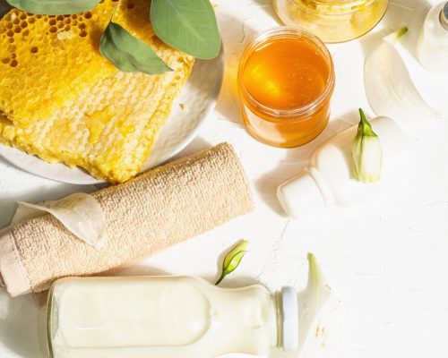 spa-concept-with-honey-milk-natural-cosmetics-organic-ingredients-hard-light-dark-shadow-white-putty-background-top-view_164638-13341